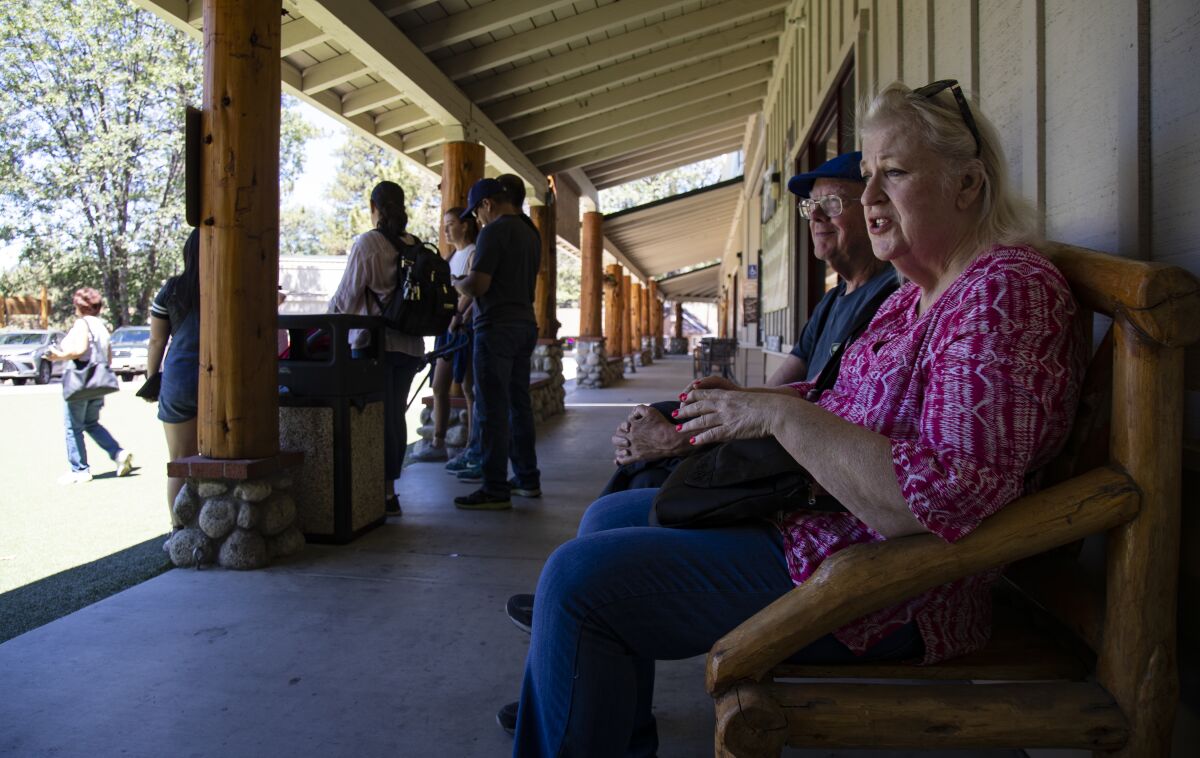 Gary Burington and Karen Bowen of San Diego sit on an Idyllwild bench,