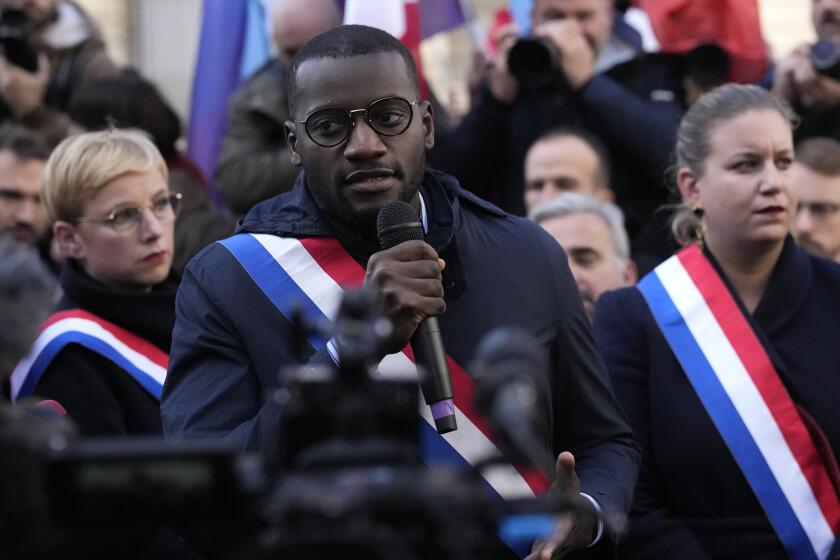 Black lawmaker Carlos Martens Bilongo speaks while lawmakers Mathilde Panot, right, and Clementine Autain, left, listen during a rally Friday, Nov. 4, 2022 outside the National Assembly in Paris. Carlos Martens Bilongo said Friday he was "deeply hurt" after a far-right member of the French parliament made a racist remark during a legislative session, something that has triggered condemnations from across the political spectrum. (AP Photo/Thibault Camus)
