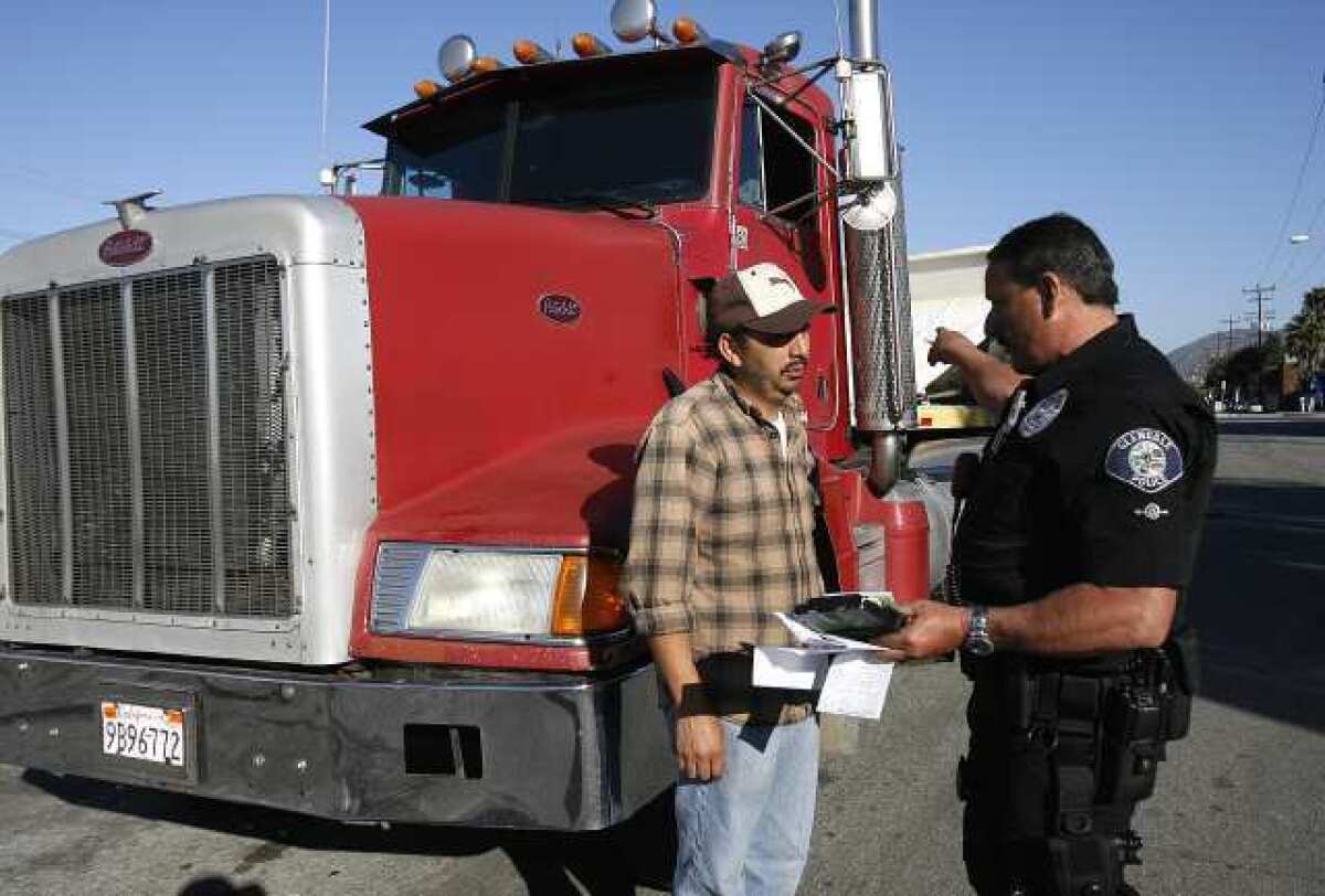 Glendale officer Joe Borbon gives Jose Lizama a ticket for problems with his truck. Law enforcement set up a commercial vehicle inspection checkpoint to check trucks for mechanics and permits.
