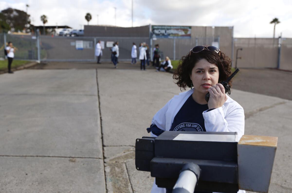 Dr. Bonnie Arzuaga tries to contact the Border Patrol as doctors and other healthcare providers from Doctors for Camp Closure were hoping to give flu shots to detained migrants at the Chula Vista Border Patrol Station in San Ysidro, Calif. on Monday.