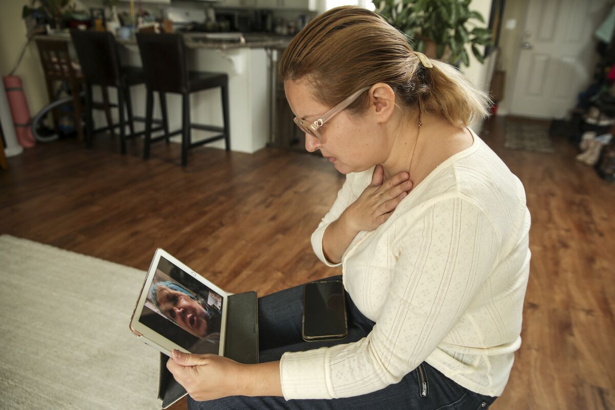A woman video-chats with her mother on a device