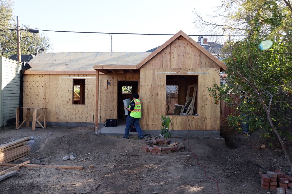 Workers building a small wooden house in West Adams.