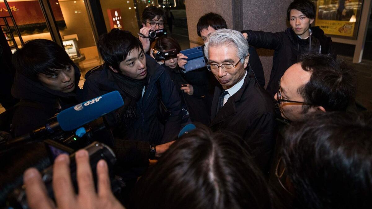 Junichiro Hironaka, center, the new lawyer of former Nissan chief Carlos Ghosn, speaks with the media outside his office building in Tokyo.