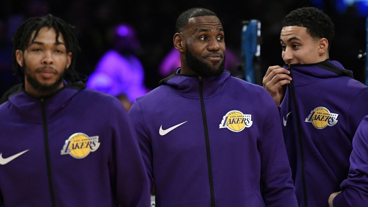 Lakers' LeBron James, flanked by Brandon Ingram, left, and Kyle Kuzma, remains sidelined.