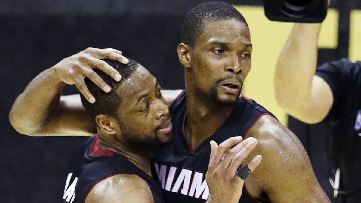 Miami Heat stars Dwyane Wade, left, and Chris Bosh celebrate during Game 2 of the NBA Finals against the San Antonio Spurs on June 8. Wade and Bosh will opt out of their contracts with the team.