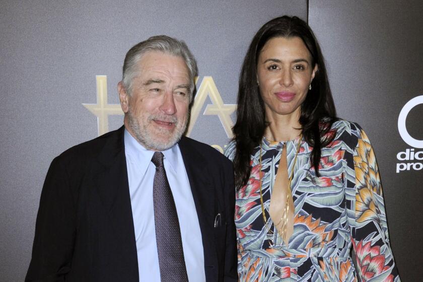 Robert De Niro and daughter Drena De Niro pose together in formal attire.