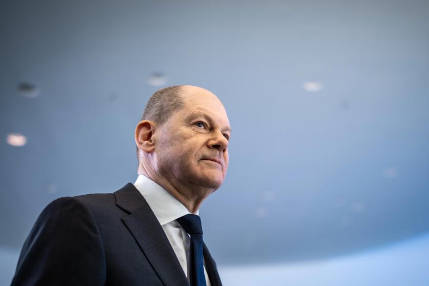 FILE - German Chancellor Olaf Scholz leaves after a news conference, ahead of a one-day closed meeting of the German Cabinet at the Chancellery in Berlin, Germany, Friday, Jan. 21, 2022. Scholz is flying to Washington this week to reassure Americans that his country stands alongside the United States and other NATO partners in opposing any Russian aggression against Ukraine. Scholz has publicly said that Moscow would pay a “high price” in the event of an attack. But his government’s refusal to supply lethal weapons to Ukraine, bolster its troop presence in eastern Europe or spell out which sanctions it would support against Russia has drawn criticism abroad and at home. (Michael Kappeler/Pool via AP, File)