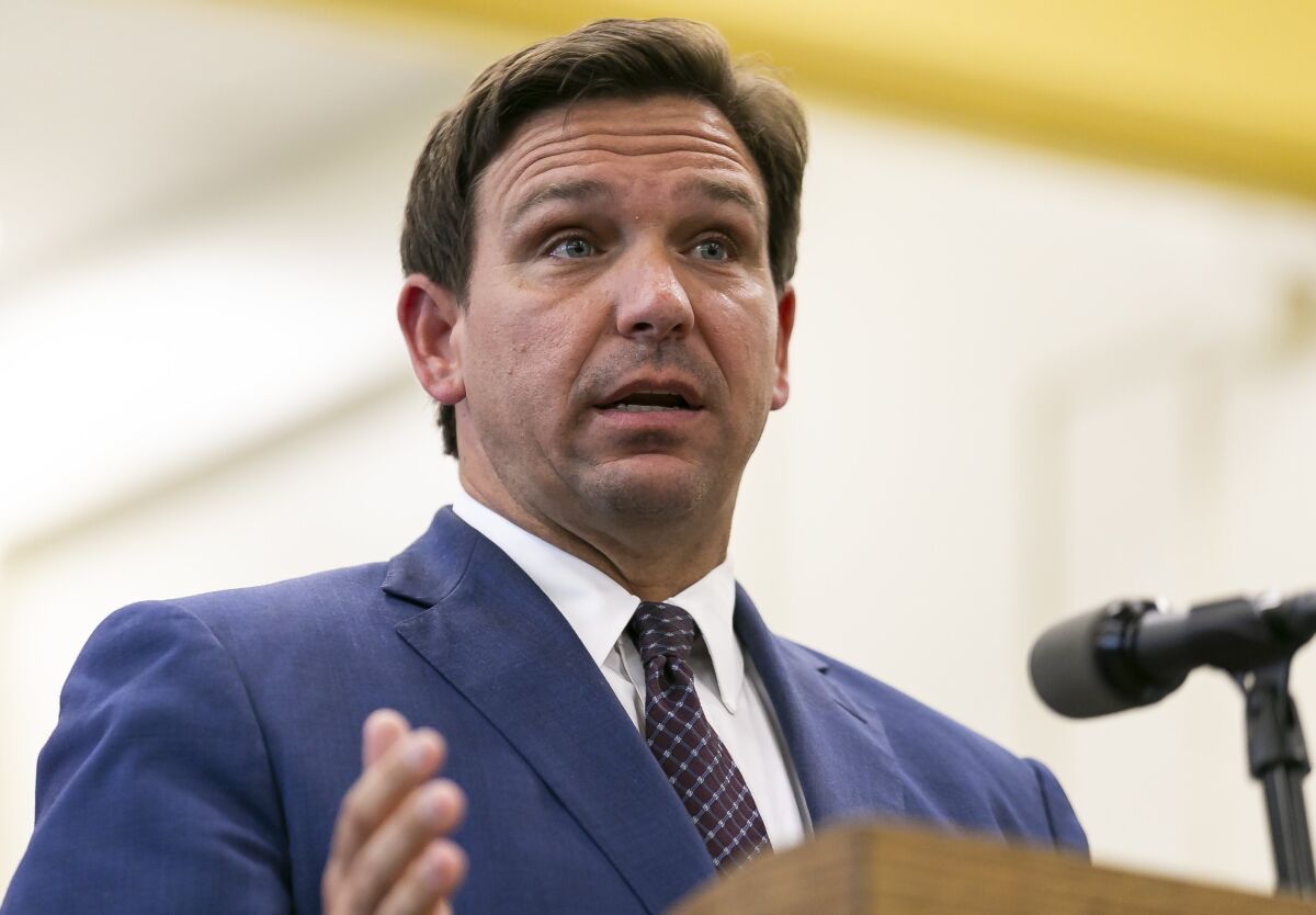 Florida Gov. Ron DeSantis, center, speaks during a news conference at West Miami Middle School in Miami on Tuesday, May 4, 2021. DeSantis signed bills revamping Florida's literacy and early childhood learning. (Matias J. Ocner/Miami Herald via AP)