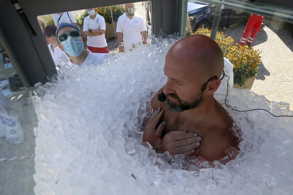 CORRECTING NAME TO KOEBERL - Austrian ice swimmer Josef Koeberl is standing in a glass cabin filled with ice try to break the world record for a human to stay side an ice box in Melk, Saturday, Sept. 5, 2020. (AP Photo/Ronald Zak)