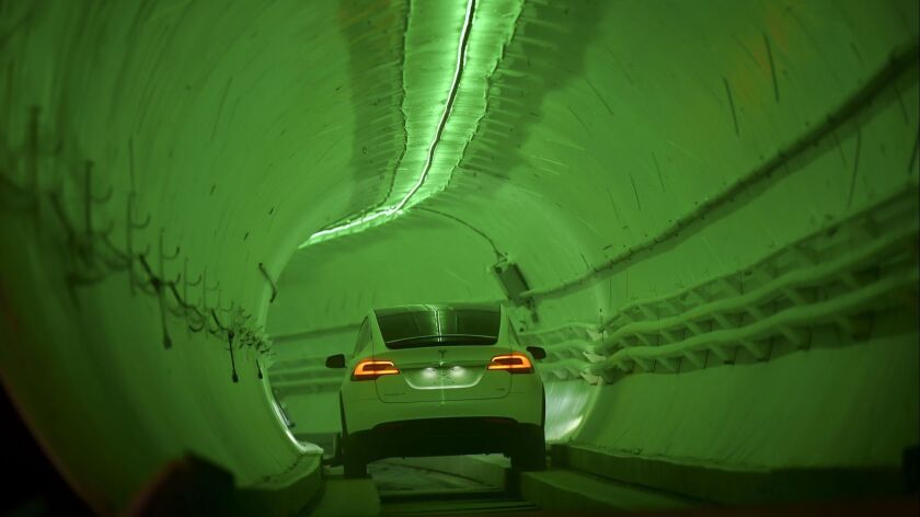 A modified Tesla Model X drives in the tunnel entrance before an unveiling event for the Boring Co. test tunnel in Hawthorne on Tuesday, Dec. 18, 2018.
