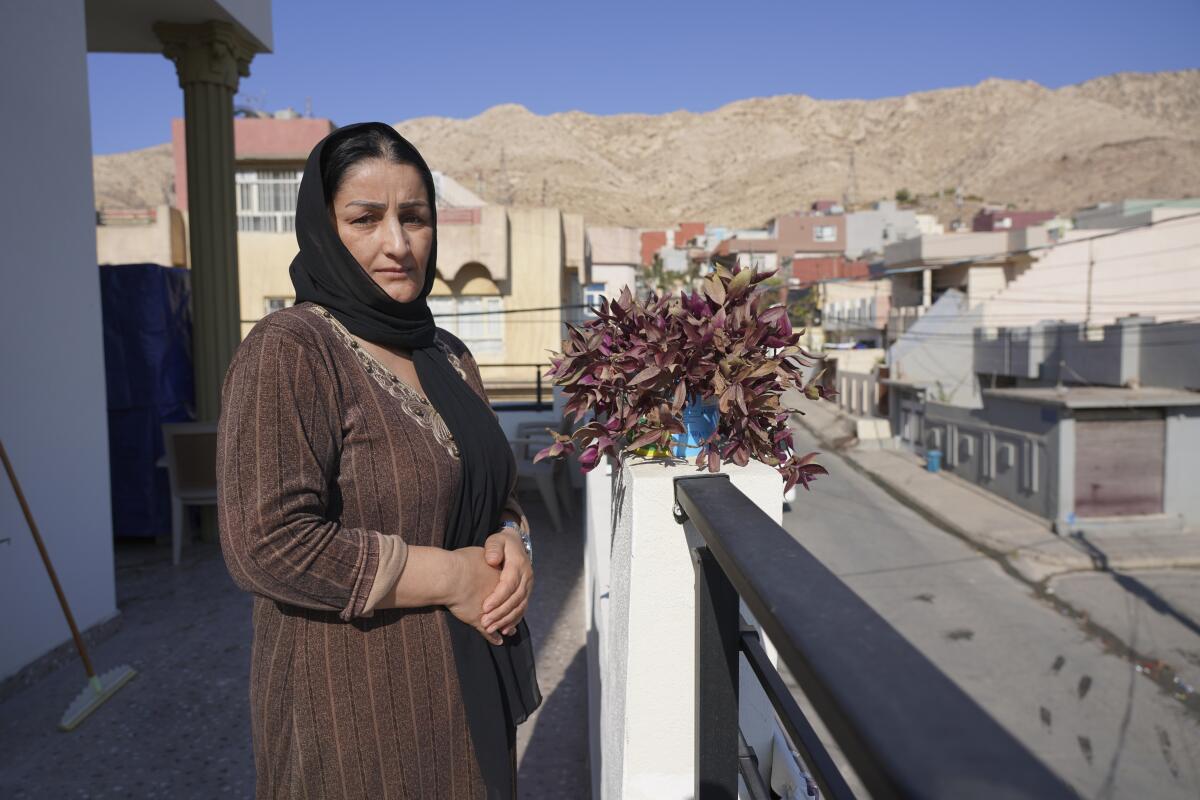 Adla Salim, the mother of the 19-year-old Sarkawt Ismat, stranded on the Belarus border, poses at her home in Dohuk, Iraq, Friday, Nov. 12, 2021. Sarkawt is among thousands from the Middle East who have been trying to slip into the EU in recent months using a backdoor quietly opened by non-EU member Belarus.(AP Photo/Rashid Yahya)