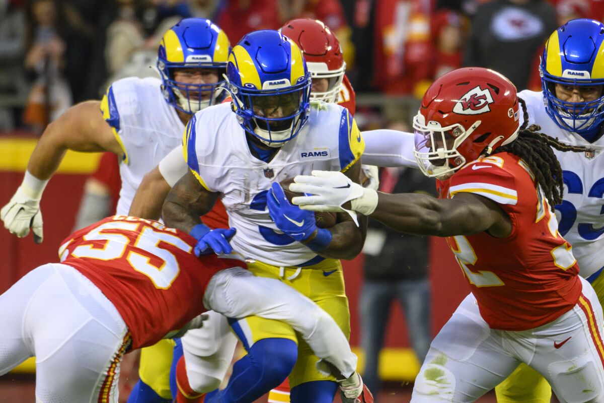Rams running back Cam Akers (3) is tackled by Kansas City Chiefs Frank Clark (55) and  Nick Bolton (32).