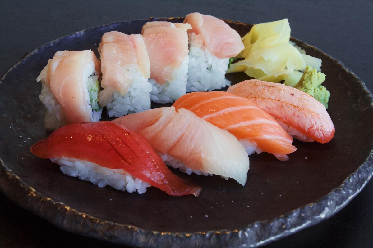 A horizontal closeup of a sushi lunch set at Ikigai on a black plate.