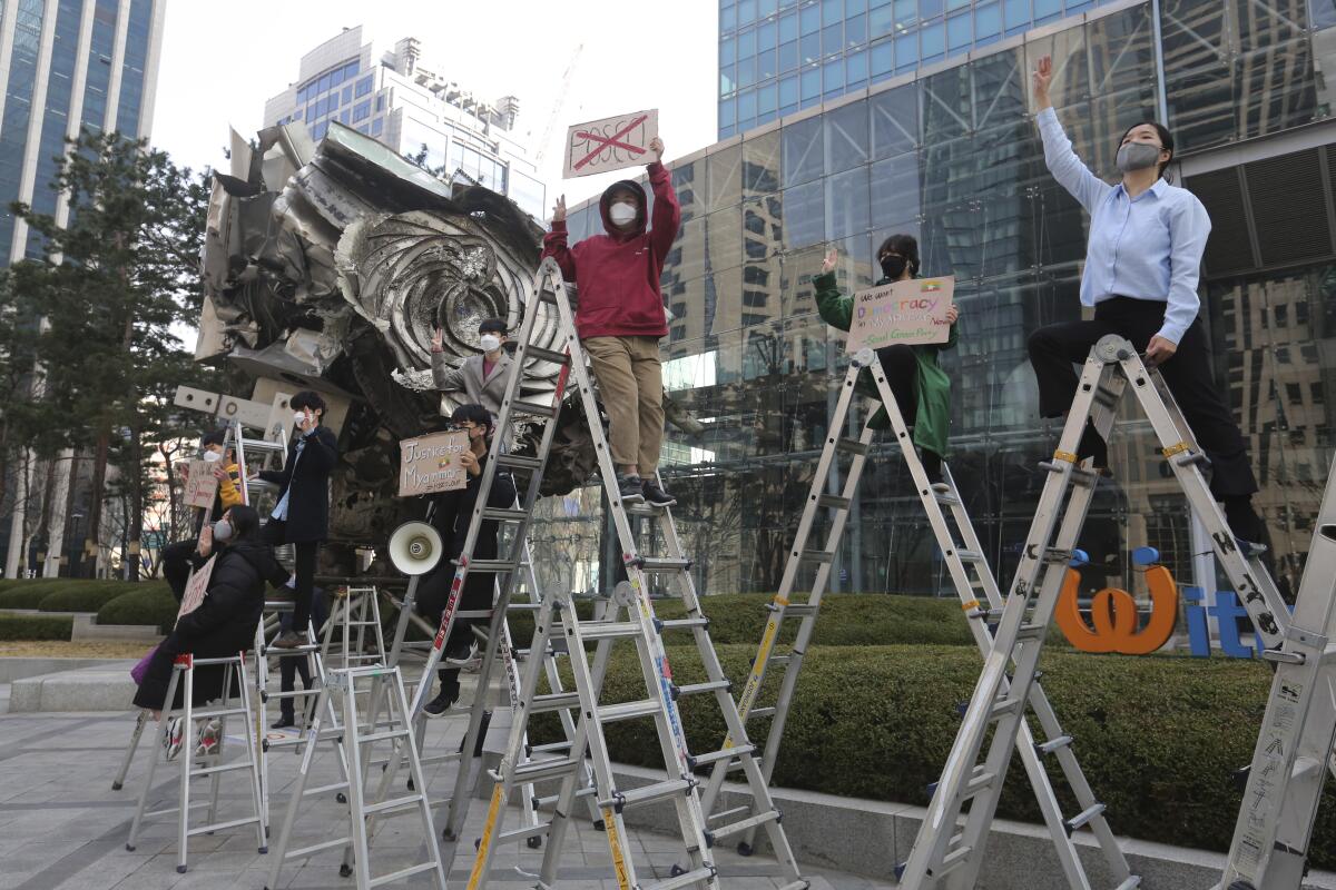 South Korean peace activists on the ladders stage a rally supporting Myanmar's democracy, outside the POSCO office in Seoul, South Korea on Feb. 22, 2021. POSCO Coated & Color Steel said Friday, April 16, 2021, it's ending a joint venture with a military-controlled firm in Myanmar following criticism that its business has benefited military leaders who have violently suppressed pro-democracy protests in the country. (AP Photo/Ahn Young-joon)