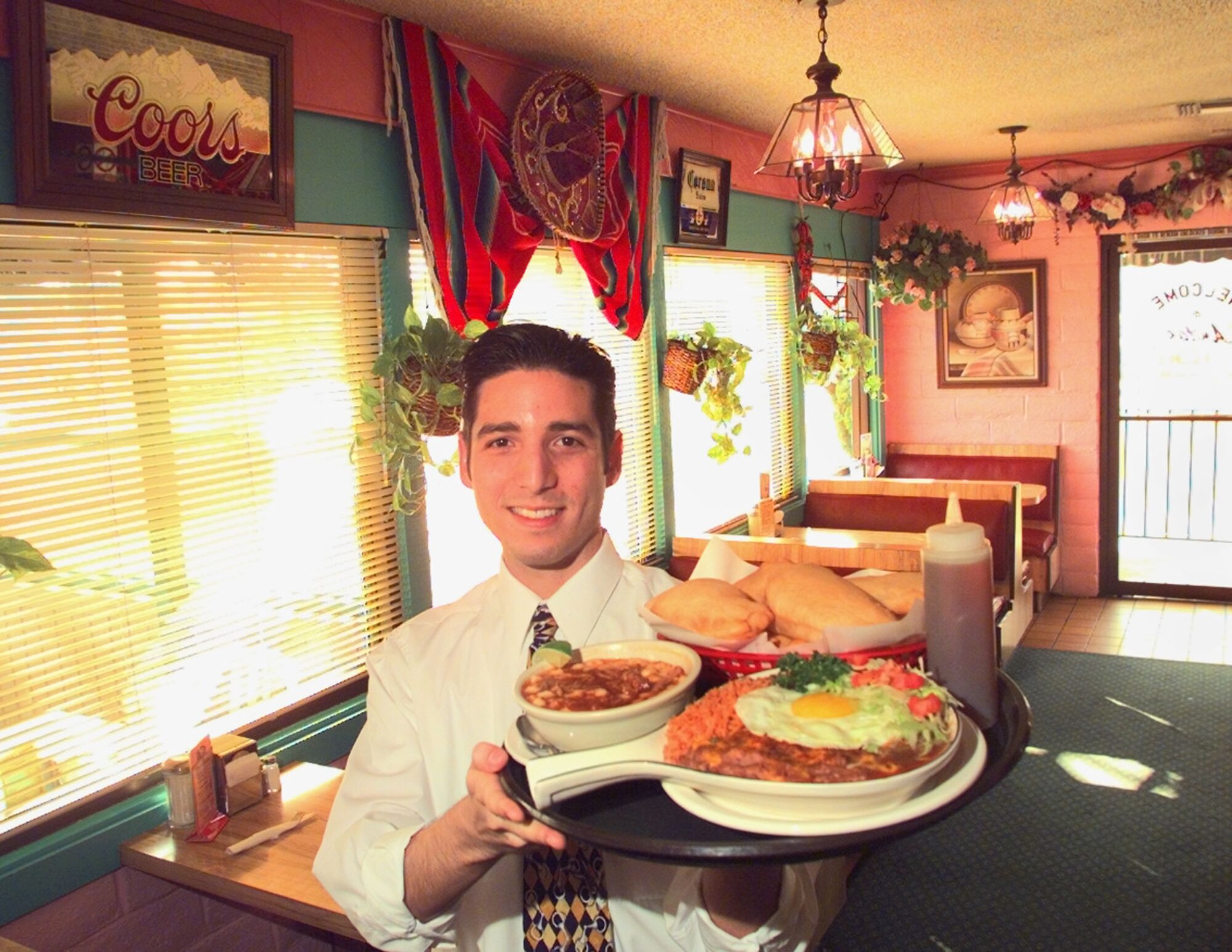 A man holding a tray of food in a restaurant.