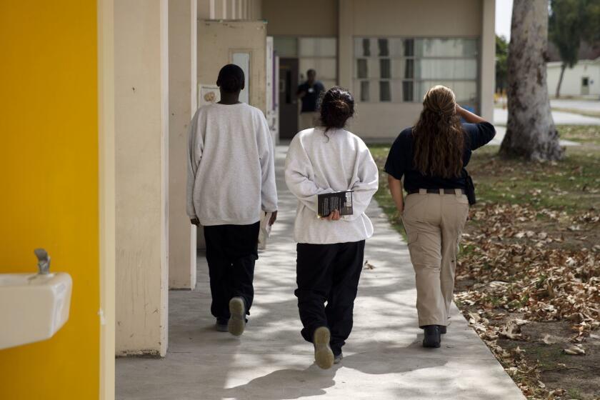 Female minors detained at the juvenile hall are escorted by a probation officer with their books after visiting the new 4,000 volume library at Los Padrinos Juvenile Hall on Monday, September 12, 2016 in Downey, Calif. Literacy specialist Zoila Gallegos used to keep a small library in her classroom so kids with reading difficulties could check out the books and led a push for a new library in the lock-up. (Patrick T. Fallon/ For The Los Angeles Times)