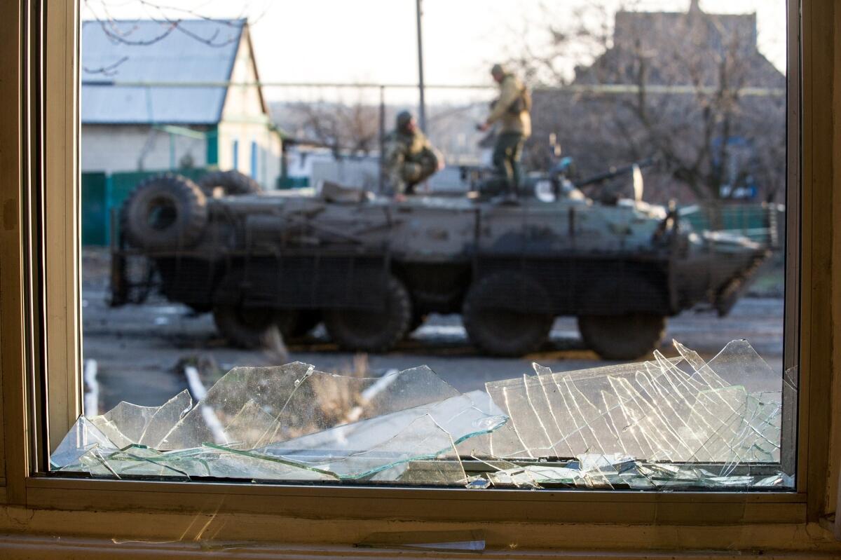 Ukrainian servicemen are seen standing on an Armoured Personnel Vehicle through a broken window in the Donetsk region.