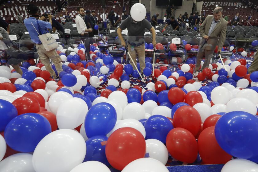 A worker at the Wells Fargo arena pop balloons at the end of the final day of the Democratic National Convention, Friday, July 29, 2016, in Philadelphia. (AP Photo/Mary Altaffer)