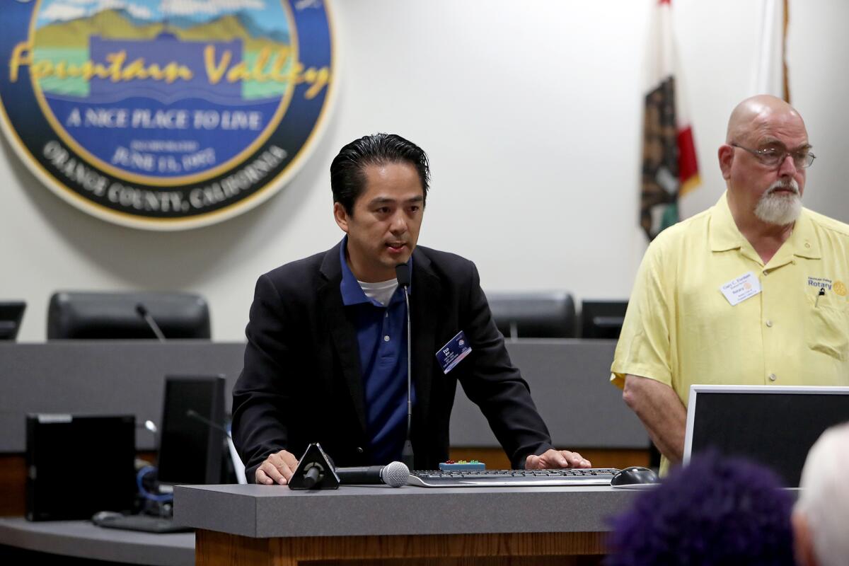 Councilman Ted Bui, left, who is president of the Fountain Valley Rotary Club, speaks Friday about the "Walk for Vietnam."