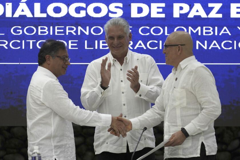 FILE - Cuban President Miguel Diaz-Canel applauds as Colombia's President Gustavo Petro, left, and ELN commander Antonio Garcia, shake hands during a bilateral ceasefire agreement signing ceremony between Petro's government and the Colombian National Liberation Army (ELN) guerrilla, at El Laguito in Havana, Cuba, June 9, 2023. ELN leaders on Tuesday, June 4, ordered their units to cease offensive actions against Colombian military forces while they negotiate a ceasefire with the Petro government. (AP Photo/Ramon Espinosa, File)