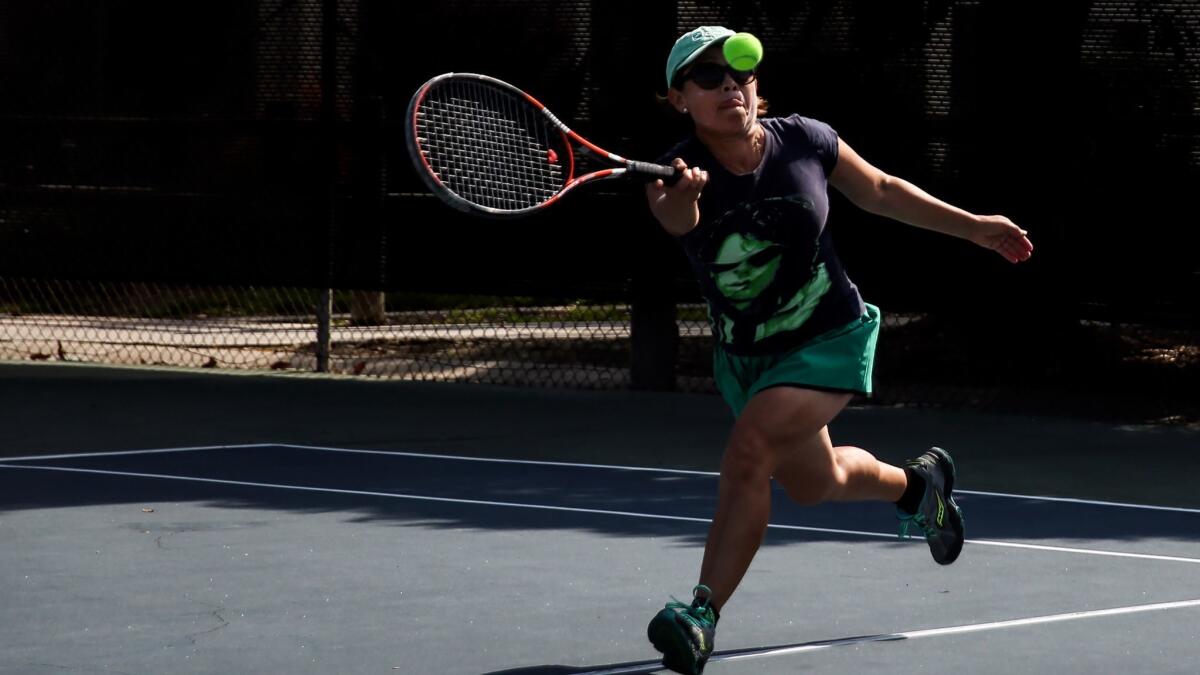 Patricia Rodriguez plays a doubles tennis match in Downey. She is the only woman player in a group of mostly retired men who meet twice a week to play tennis.