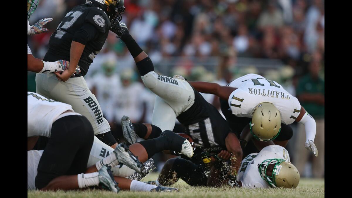 Narbonne running back Justin Franks is slammed to the turf by Long Beach Poly defenders after a short gain in the first half on Thursday night at Narbonne High.
