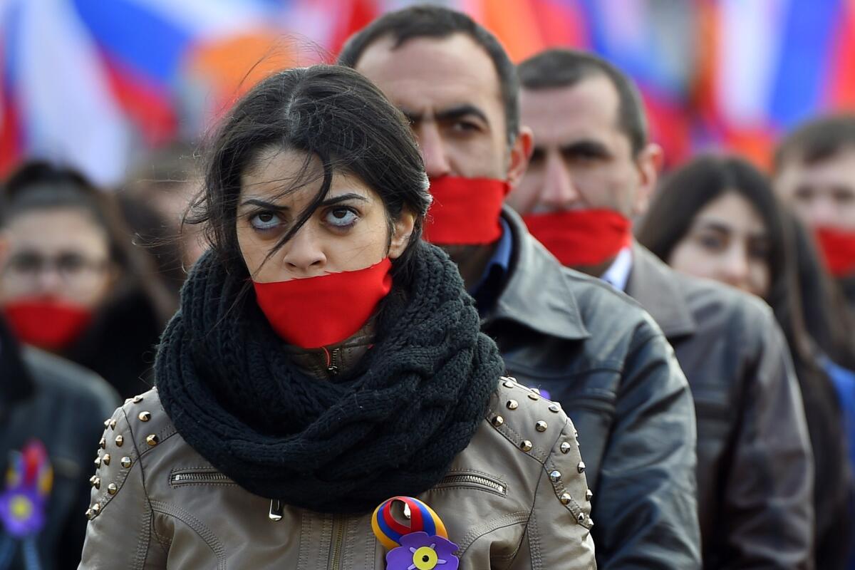 People wearing gags gather in central Moscow to mark the 100th anniversary of the Armenian genocide.