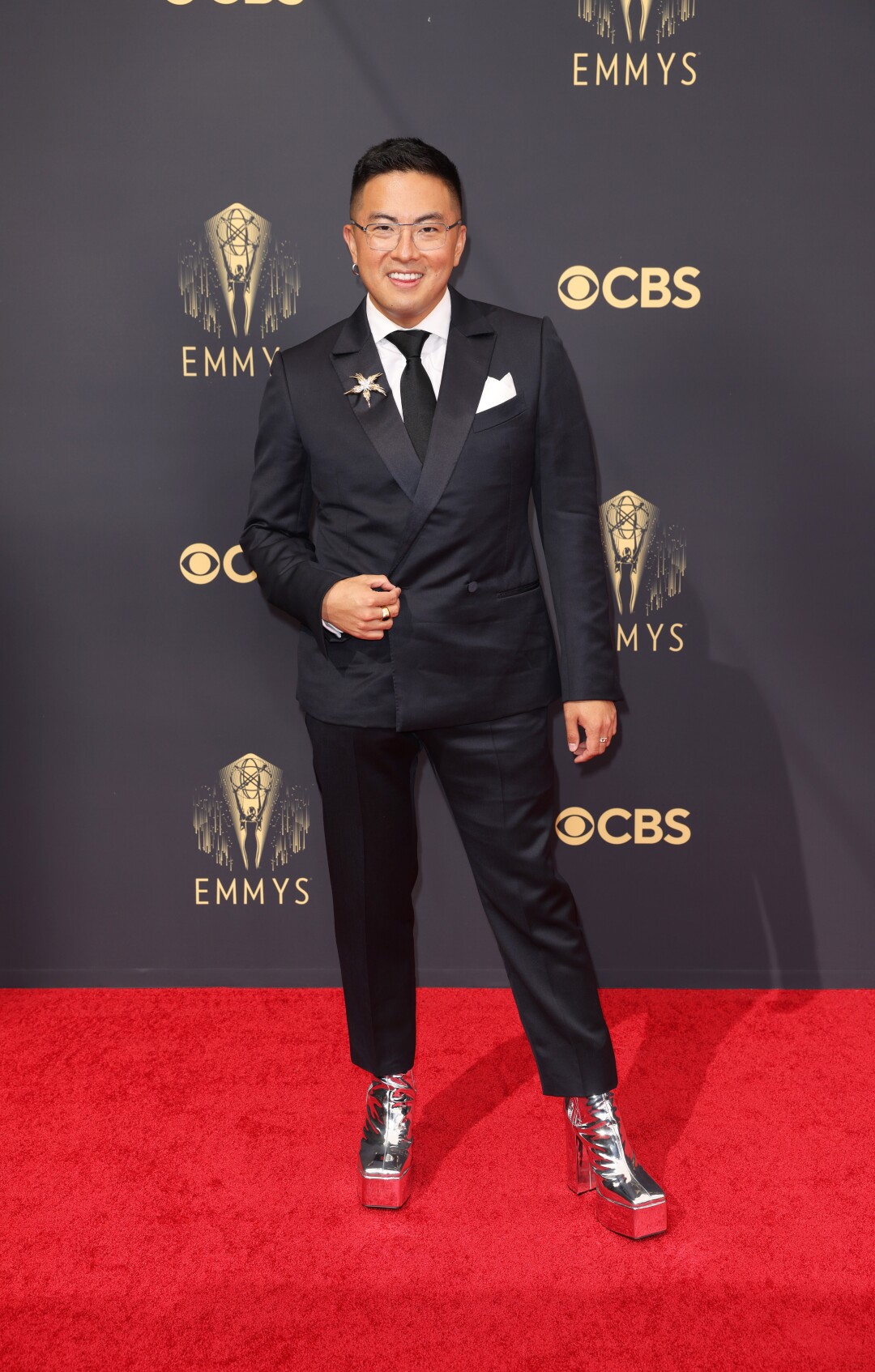Bowen Yang in a tux with silver boots on the red carpet.