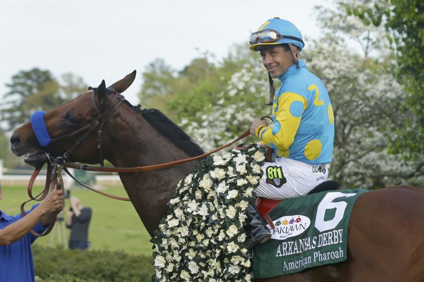 Jockey Victor Espinoza poses with American Pharoah in the winners circle after winning the Arkansas Derby in April.