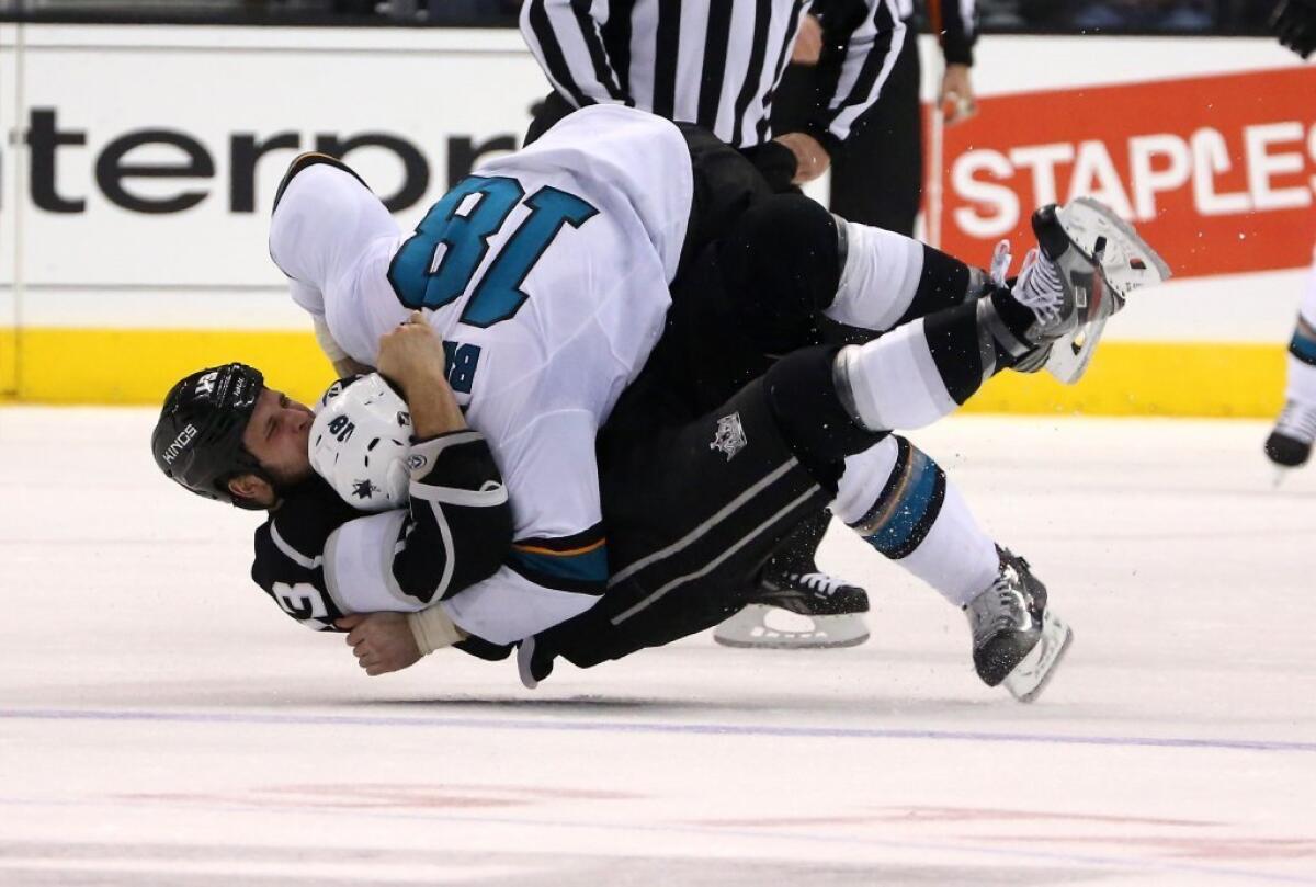 Mike Brown, top, of the Sharks and Kyle Clifford of the Kings go to the ice as they fight in the first period at an Oct. 30 game.