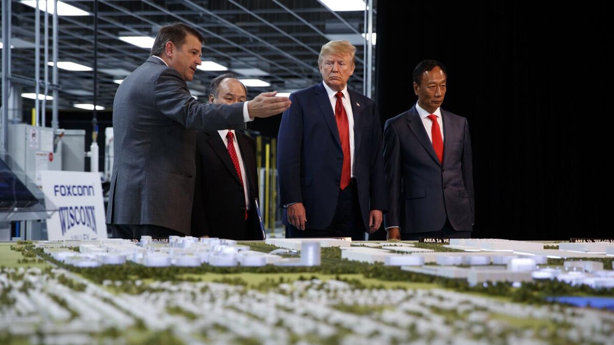 President Trump, second from right, looks at Foxconn's plans for a factory in Mt. Pleasant, Wis., with Foxconn Chairman Terry Gou, right, in 2018. Foxconn, which won a $4.5-billion incentive package from Wisconsin, indicated it is reconsidering developing LCD displays there.
