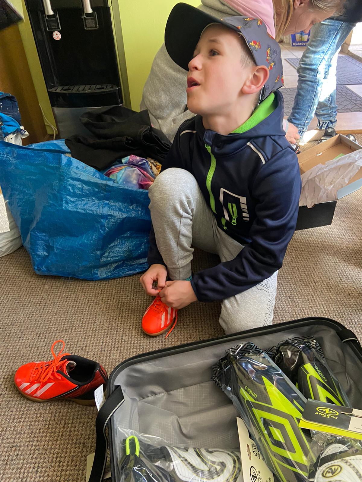 A Ukranian boy gets fitted for soccer cleats that the Haneys brought over.