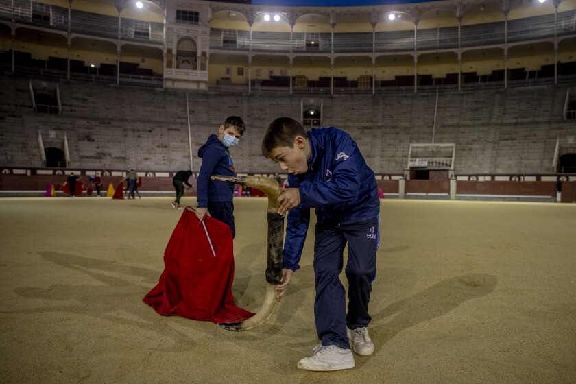 Pupils Nicolas Sanz Luna, 10, right, performs holding a plastic bull horns with Daniel at the Bullfighting School at Las Ventas bullring in Madrid, Spain, Tuesday, Dec. 22, 2020. They are students of the Bullfighting School at Las Ventas bullring in Madrid, where children as young as 9 can begin learning this deadly dance of human and beast so closely associated with Spanish identity. The school was closed from March to August when Spain went into one of the world's strictest confinements to stem the spread of the COVID-19 pandemic.(AP Photo/Manu Fernandez)