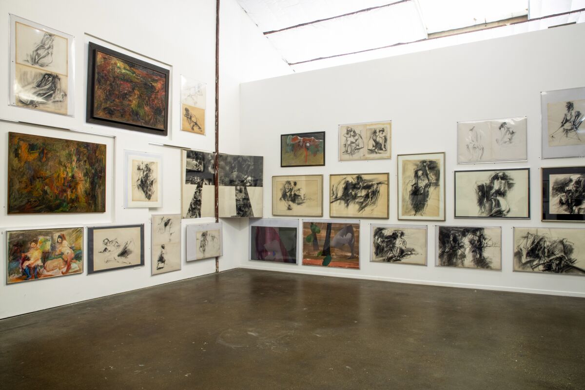 A view of a gallery shows a salon-style hang with abstracted pictures in color and black and white