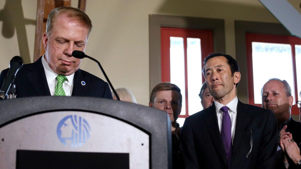 Seattle Mayor Ed Murray announces he is dropping his reelection bid. At right is his husband, Michael Shiosaki.