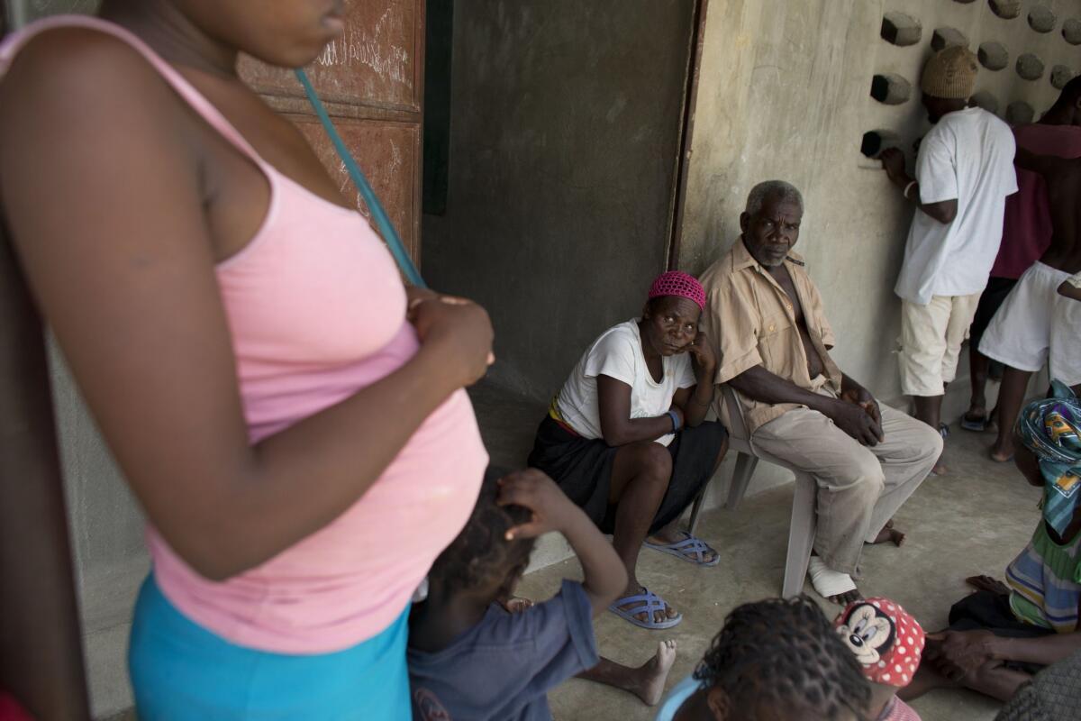Haitians recently deported from neighboring Dominican Republic sit outside a school building where residents have allowed them to stay in the village of Fonbaya on June 18.