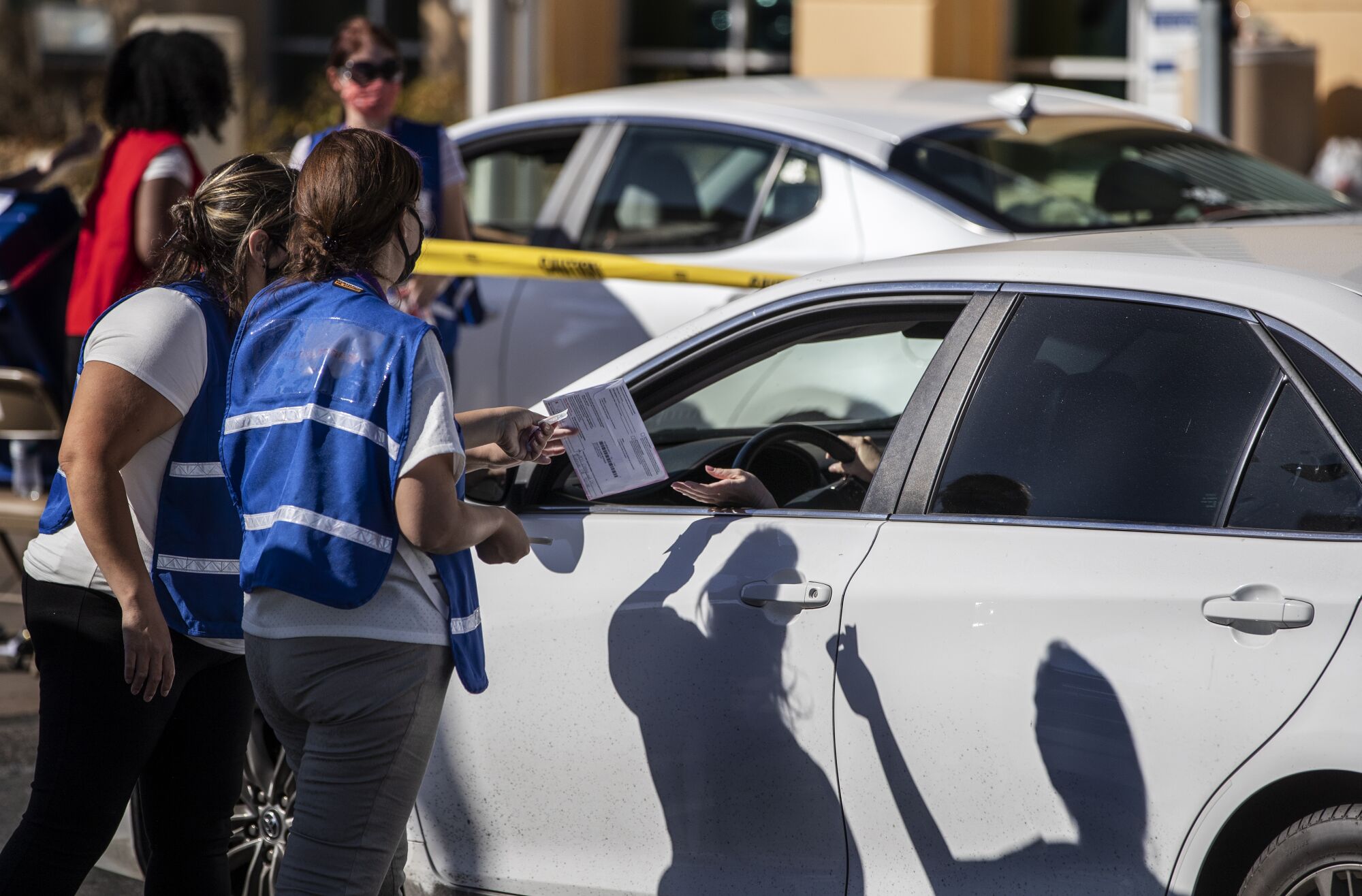 A woman hands her ballot to an election worker outside the Riverside County registrar of voters office.