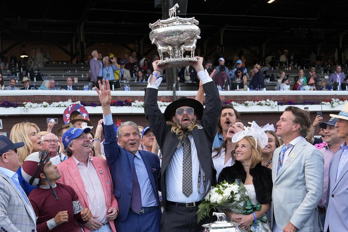 Dornoch co-owner Jayson Werth, center, holds up the August Belmont Memorial Cup.