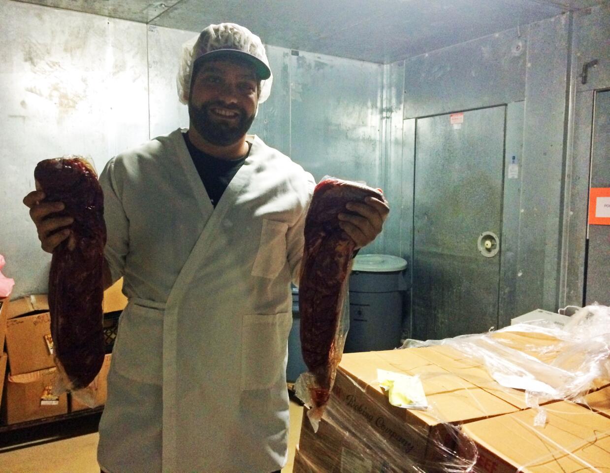 Daniel Fogelson holds two beef tenderloins on their way to becoming jerky at the Settlers Jerky Inc. facility in Walnut, Calif.