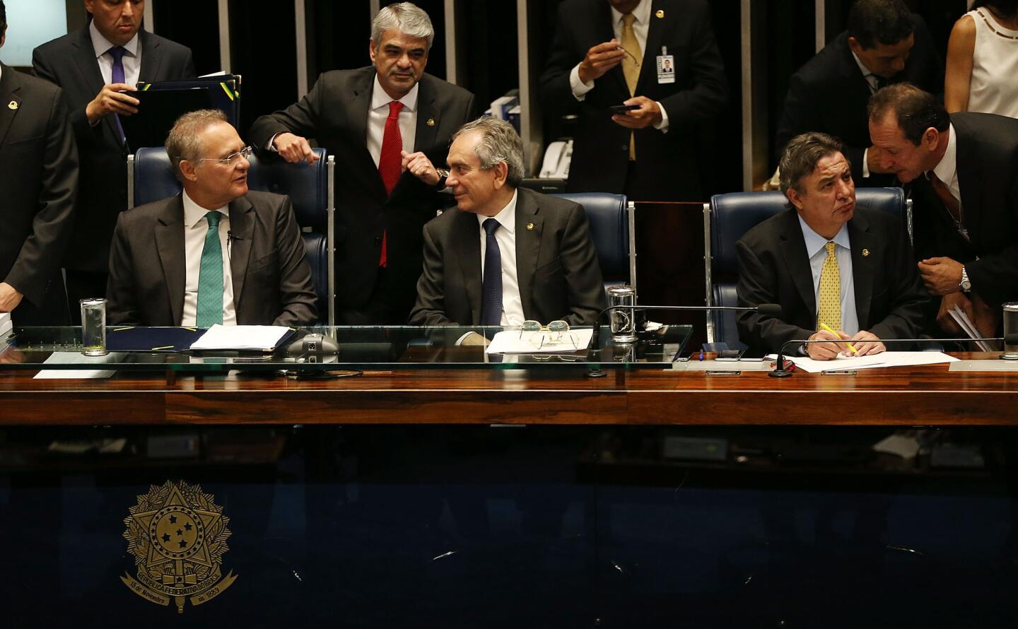 Brazilian Senate President Renan Calheiros, left, sits with other lawmakers during a special session in the Brazilian Senate to vote on whether to accept impeachment charges against embattled President Dilma Rousseff in Brasilia.