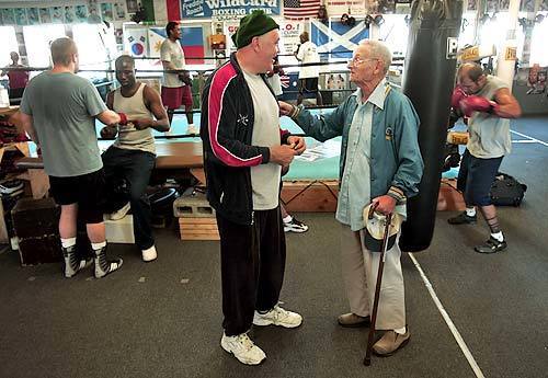 Arnie Koslow tells stories to former boxer Macka Foley at the Wild Card Boxing Club in Hollywood. Koslow worked one of Foley's last fights in Tijuana, Mexico.