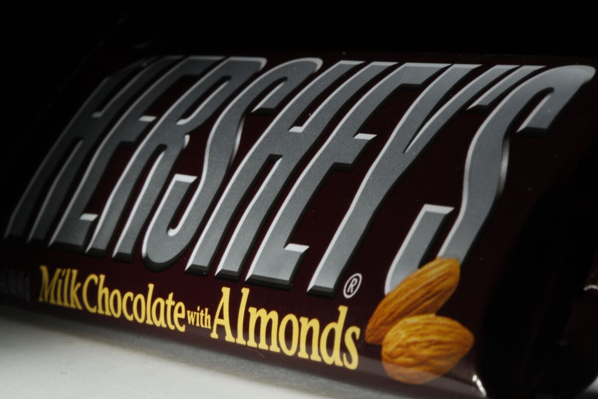 FILE - This April 21, 2020 file photo shows a Hershey's chocolate bar with almonds in Philadelphia. Hershey says its Halloween candy sales were up slightly this year despite lower enthusiasm for trick-or-treating amid the pandemic. Michele Buck _ chairman, president and CEO of The Hershey Co. _ said Friday, Nov. 6, 2020, that earlier shipments of Halloween candy to stores helped boost sales. (AP Photo/Matt Rourke, File)