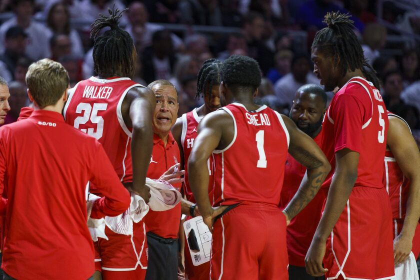 Houston head coach Kelvin Sampson, third from left, talks with his team during the first half of an NCAA college basketball game against Temple, Sunday, Feb. 5, 2023, in Philadelphia. (AP Photo/Chris Szagola)