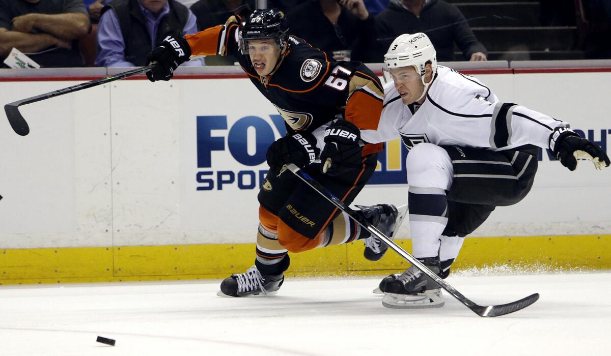 Ducks center Rickard Rakell (67) tries to beat Kings defenseman Brayden McNabb to a loose puck during their game March 18 at the Honda Center.