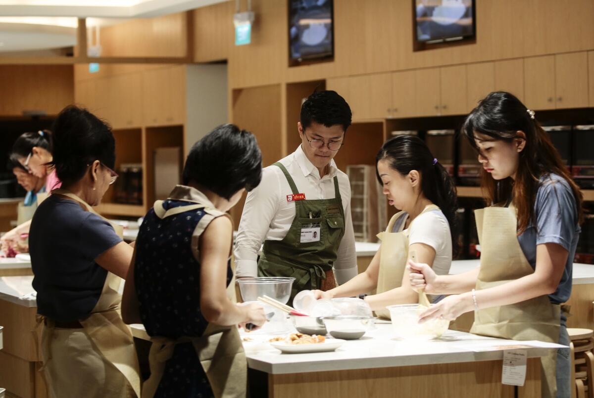 Students take part in a cooking class in the Funan Mall in Singapore.