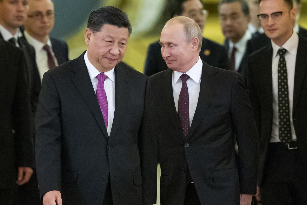 Chinese President Xi Jinping and Russian President Vladimir Putin walk together.