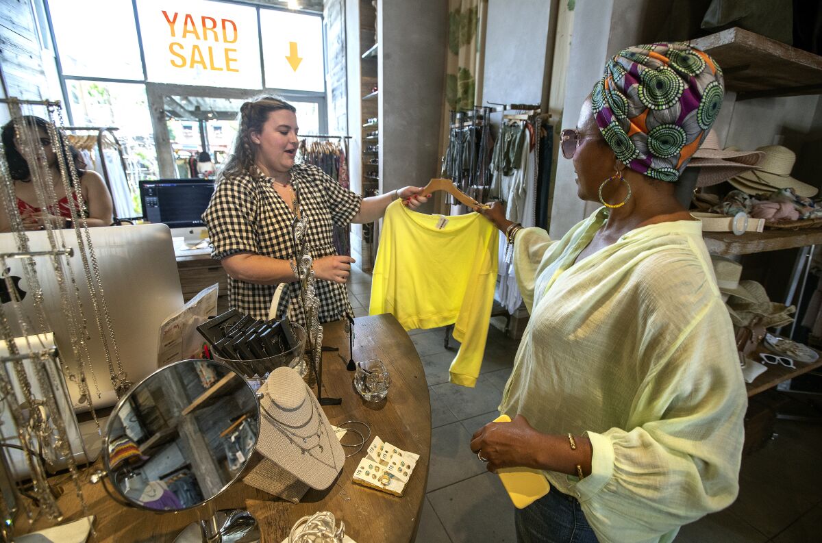 An employee, left, helps a customer inside Hardwear, a clothing store on Larchmont Boulevard.