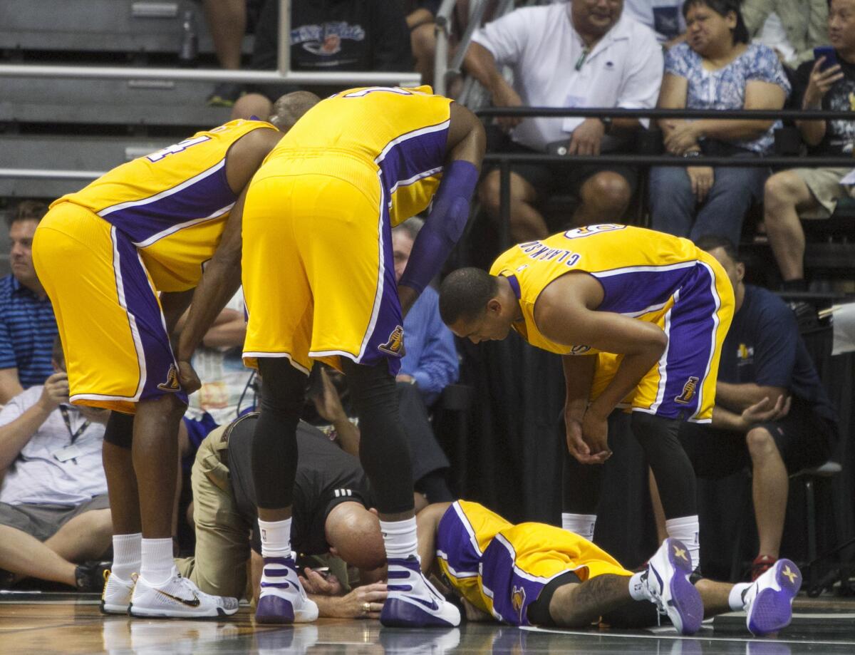 Teammates look over Lakers guard D'Angelo Russell after he crashed to the ground during the first quarter of a preseason game against the Jazz. Russell did not return.
