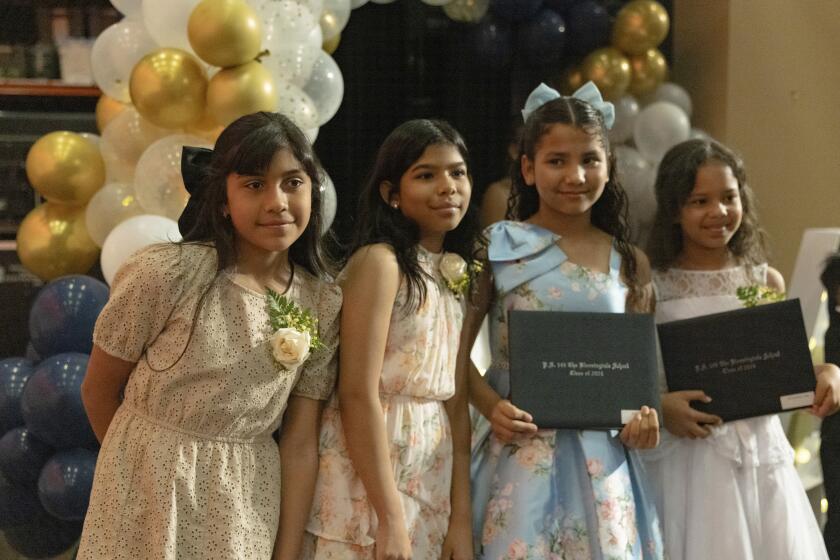 Sophia Prado, izquierda, se toma una fotografía con compañeras de aula después de la ceremonia de graduación de P.S. 145, The Bloomingdale School, el viernes 21 de junio de 2024, en Nueva York. Miles de familias migrantes en la ciudad de Nueva York desconocen cómo afrontarán las necesidades educativas de sus hijos, tanto este verano como el próximo año escolar. (AP Foto/Jeenah Moon)