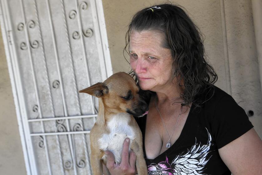 Kathleen Anderson holds her dog Mugsy; her husband, Johnny Ray Anderson, was fatally shot by a sheriff's deputy July 5 and the Hawaiian Gardens City Council has asked for an FBI investigation of the shooting.